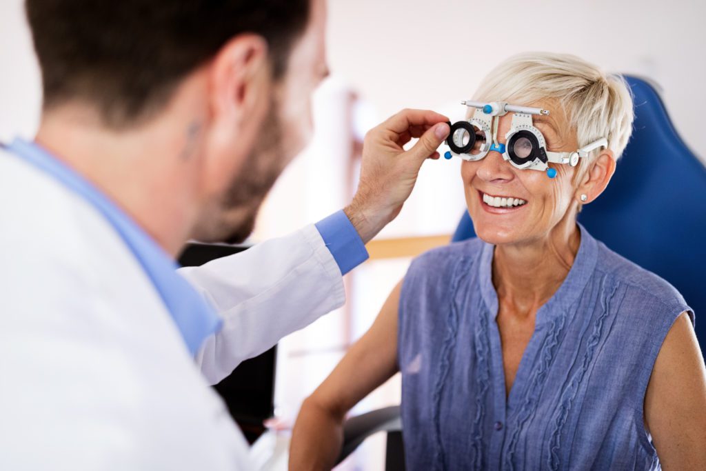 Senior woman taking an eyesight test examination at an optician clinic